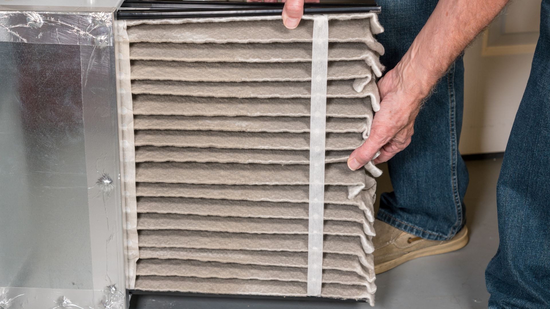 person removing a dirty air filter