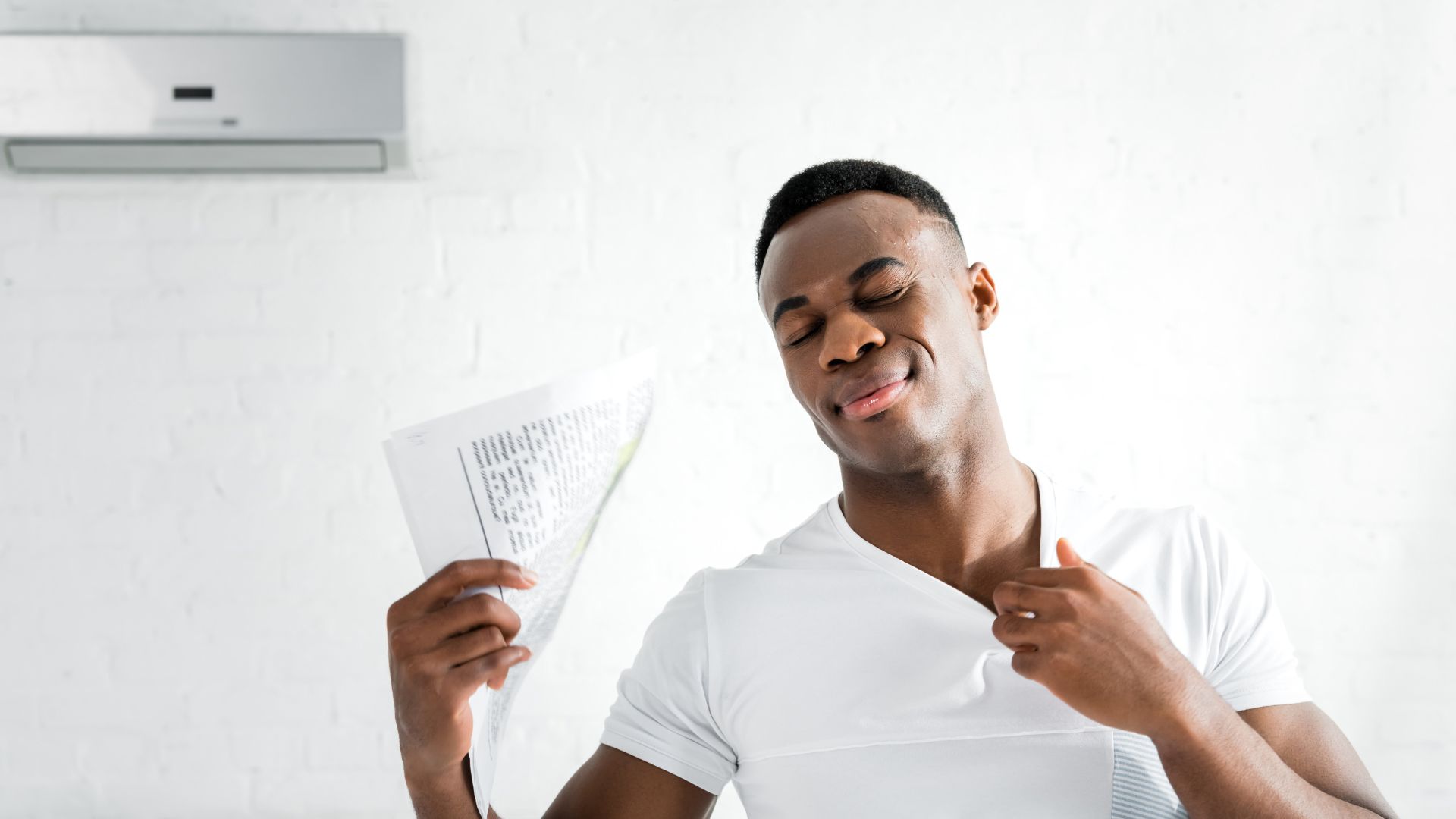 a man fanning himself in his home