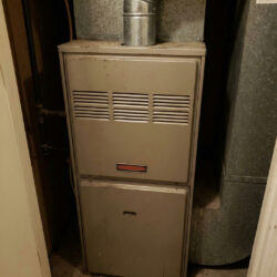 an older, hardworking residential furnace in a utility closet