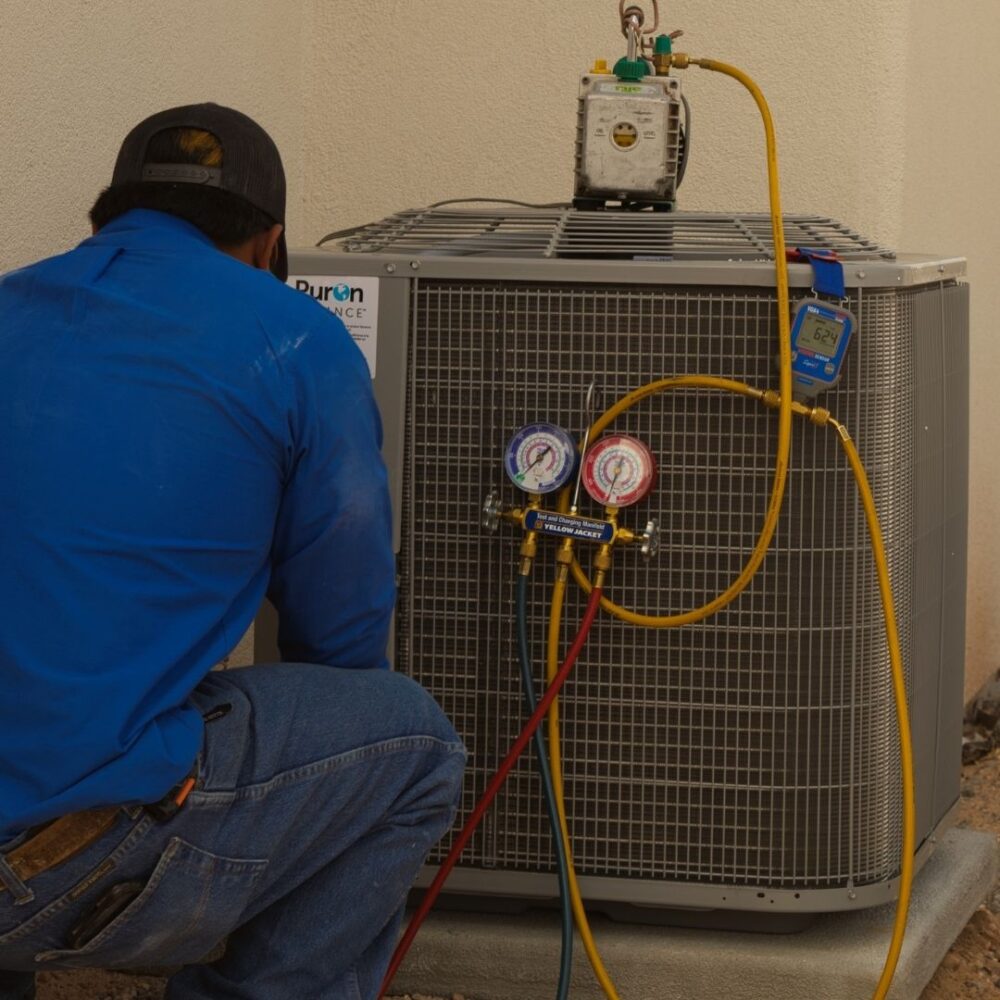 Technician gently working on an outdoor HVAC unit.